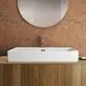 Waschtisch von Ideal Standard mit rechteckiger, weißer Keramikschale auf Holzoberfläche, ergänzt durch einen modernen Wasserhahn und runder Spiegelfläche im Hintergrund.